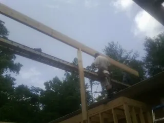 Carpenter setting a ridge beam over a new addition frame — Ice Dam Removal by Roofing Brothers in River Grove