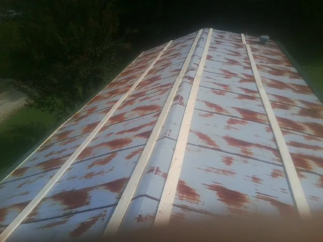 Rusted metal roof panels with new wood purlins before replacement — Storm Damage Roof Repair in River Grove by Roofing Brothers